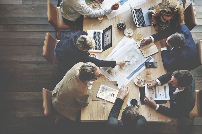 An aerial view of office workers collaborating around a table.